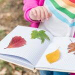 A child adds leaves to a journal.